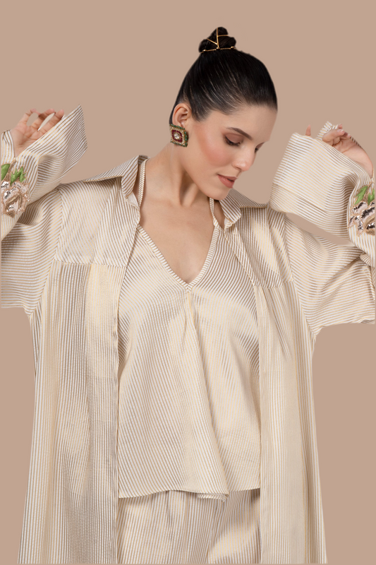 Cream and gold pinstripe jacket, top and pant.  Embroidered motif on cuffs.